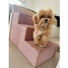 Maltipoo kutyus áll a rózsaszín kutyalépcsőjén